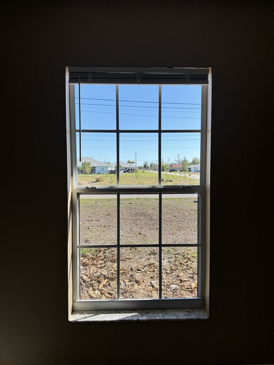 Clear view of a Cape Coral street through a freshly cleaned double-hung grid window